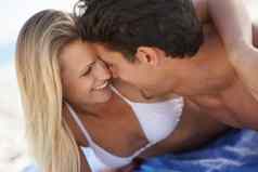 爱充满深情的年轻的夫妇接吻海滩