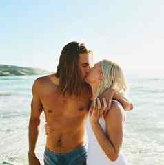 单词需要爱充满深情的年轻的夫妇接吻海滩