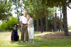 快乐高尔夫球手全身的肖像快乐高级夫妇站袋高尔夫球俱乐部高尔夫球