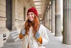 快乐女孩旅行者红色的长头发走城市观光徒步旅行欧洲冬天