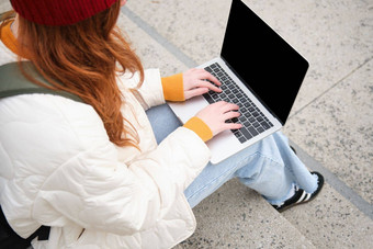后视图女孩学生打字移动PC键盘空白黑色的屏幕网站应用程序广告坐着楼梯在户外连接公共无线网络