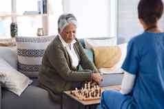 小心翼翼地移动高级女人玩国际象棋年轻的护士退休首页