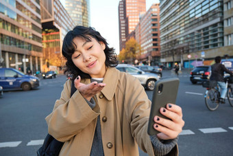 可爱的朝鲜文女孩旅游需要自拍<strong>视频</strong>聊天朋友发送吻相机记录<strong>视频</strong>博客<strong>街道</strong>城市智能手机