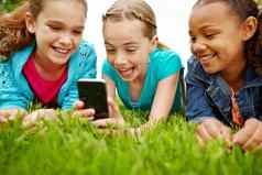 应用程序有趣的女孩支出时间分享智能手机在户外