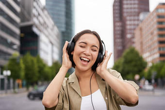 <strong>跳舞女</strong>孩感觉快乐城市亚洲女人<strong>跳</strong>舞听音乐耳机摆姿势街