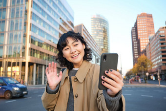 快乐亚洲女孩旅游需要自拍城市中<strong>心</strong>使<strong>视频</strong>调用波智能手机相机问候电话