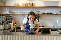 微笑亚洲女孩咖啡师工作咖啡馆酝酿咖啡准备订单计数器