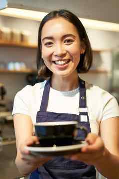 肖像微笑亚洲女人围裙咖啡师给杯咖啡工作咖啡馆服务饮料