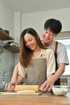 爱的亚洲丈夫妻子有趣的使面包现代厨房享受支出免费的周末时间