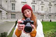 快乐红色头发的人女孩旅游需要照片摄影师专业相机走城市捕捉美丽的图片