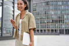 肖像亚洲女孩移动PC工作大学持有智能手机微笑走街