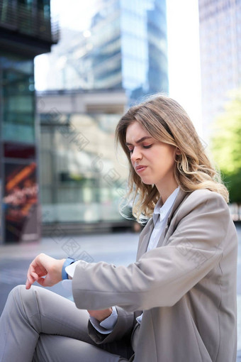 肖像办公室工人西装女人看失望脸阅读令人心烦意乱的消息坐着在户外