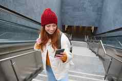 户外拍摄年轻的女人计划路线地图智能手机应用程序楼梯背包微笑