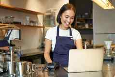 肖像年轻的女孩咖啡馆老板移动PC采取订单服务客户咖啡商店