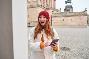 旅游观光概念年轻的红色头发的人女人旅游走城市智能手机应用程序历史站探讨了冒险