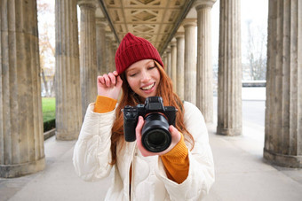 年轻的红色头发的人女摄影师使生活方式拍摄城市中心需要照片微笑完美的拍摄使图片