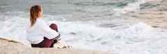 海滩女人放松和平思考岩石平静积极的心态看海洋波自由愿景户外Zen冥想正念精神健康悉尼海边