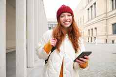 旅游技术美丽的红色头发的人女孩旅游路线应用程序城市地图智能手机阅读观光的地方移动电话