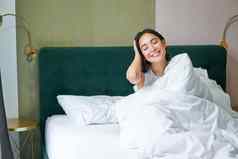快乐朝鲜文女人醒来酒店房间说谎床上舒适的温暖的毯子白色表享受周末早....