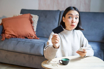 年轻的女人生活房间显示信贷卡智能<strong>手机支付</strong>订单在线购物应用程序