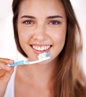 微笑惊人的年轻的漂亮的女孩刷牙牙齿