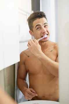 刷牙牙齿健康好处英俊的年轻的男人。刷牙牙齿浴室