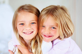 快乐年轻的女孩拥抱可爱的妹妹特写镜头肖像快乐年轻的女孩拥抱可爱的妹妹