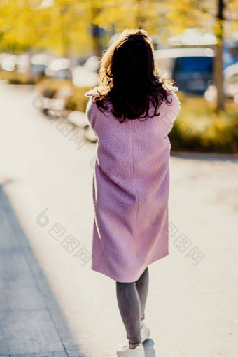 女人秋天城市女人粉红色的人造皮毛外套摆姿势城市街秋天阳光明媚的一天树黄色的树叶街