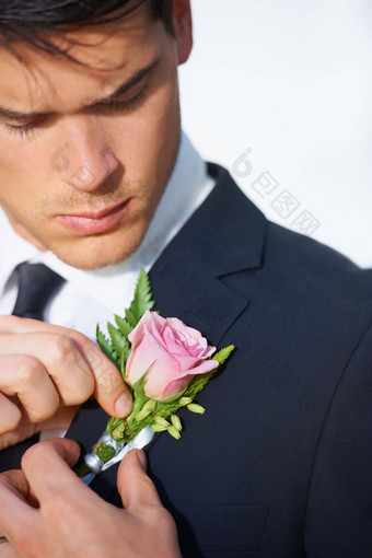 一分钟调整英俊的年轻的新郎锁住粉红色的玫瑰夹克