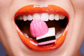甘草嘴唇美丽的年轻的女人吃甘草糖果
