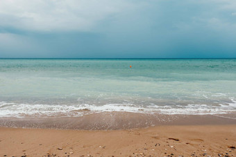 阴天空多雨的一天泡沫波滚动金沙子海滩<strong>低温</strong>暖的太阳光假期娱乐概念摘要航海夏天海洋日落自然