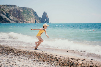 可爱的女孩运行海滨清晰的蓝色的海喜乐射线夏天太阳美丽的女孩黄色的泳衣运行有趣的热带海滩