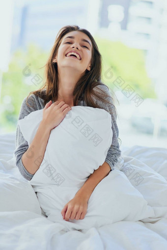 爱枕头有吸引力的年轻的女人坐着床上拥抱枕头眼睛关闭首页一天