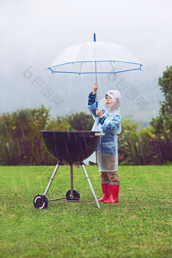 屏蔽烧烤天气完整的长度拍摄年轻的男孩<strong>站前</strong>面户外烧烤雨