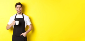 快乐的咖啡师黑色的围裙服务咖啡眨眼站黄色的背景