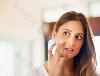 净化语气湿润保护健康的皮肤年轻的女人应用保湿霜脸
