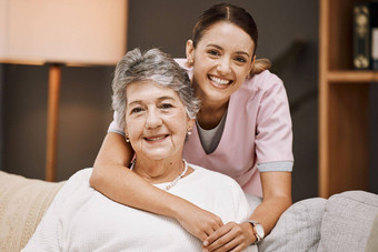 支持肖像护士高级女人沙发生活房间护理首页医疗保健健康照顾者拥抱上了年纪的女养老金领取者退休房子诊所
