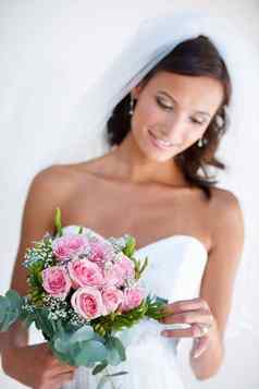 欣赏花束华丽的年轻的新娘持有花束