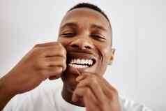 用牙线清洁牙齿重要的年轻的男人。用牙线清洁牙齿牙齿浴室首页