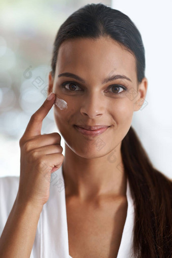 投资质量皮肤护理产品特写镜头肖像华丽的年轻的女人应用保湿霜皮肤