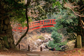 红色的桥十字架岩石溪草木丛生的日本景观