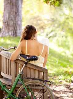 逃避后视镜拍摄年轻的女人坐着板凳上自行车