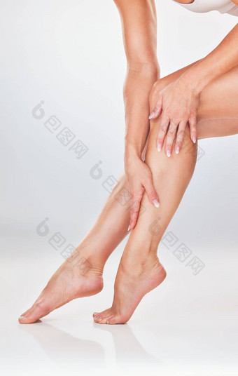 女人手腿护肤品保湿霜光滑的软自然护理白色工作室背景女手触碰腿滋润噪音乳液皮肤化妆品治疗