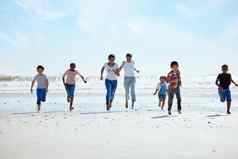 夏天海滩集团孩子们运行沙子友谊有趣的海洋假期朋友孩子们能源青年快乐男孩女孩假期好玩的比赛海