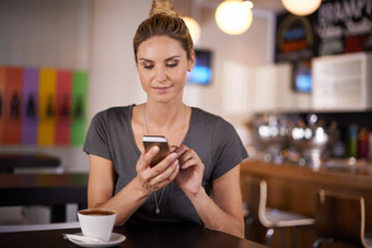学位发短信有吸引力的女人发短信坐着咖啡商店