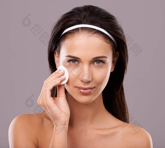 护肤品年轻的女人擦拭脸棉花羊毛