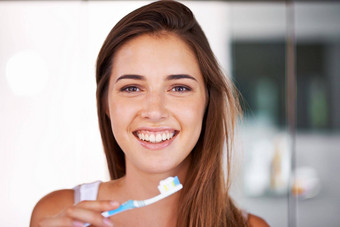 微笑惊人的年轻的漂亮的女孩刷牙牙齿