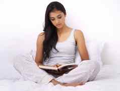 早期开始研究年轻的女人阅读书坐着床上