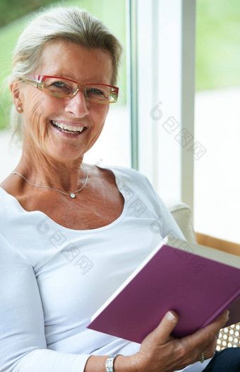 阅读至关重要的肖像微笑高级女人阅读好书首页