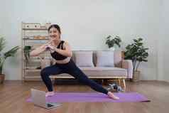 健康的亚洲女人练习放松瑜伽首页支出时间玩首页概念